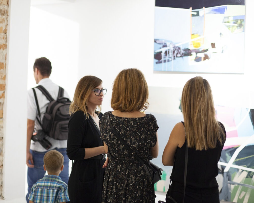 Grupa ludzi na otwarciu wystawy w galerii sztuki